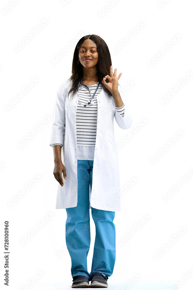 A female doctor, on a white background, in full height, shows the ok sign A female doctor, on a white background, in full height, shows the ok sign