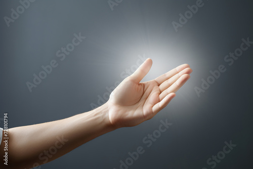 Light comes from a woman's hand against the background of a gray empty wall. Concept of spiritual life, support. Generated by artificial intelligence