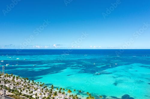 Fototapeta Naklejka Na Ścianę i Meble -  Tropical beach with resorts, palm trees and caribbean sea. Dominican Republic. Aerial view