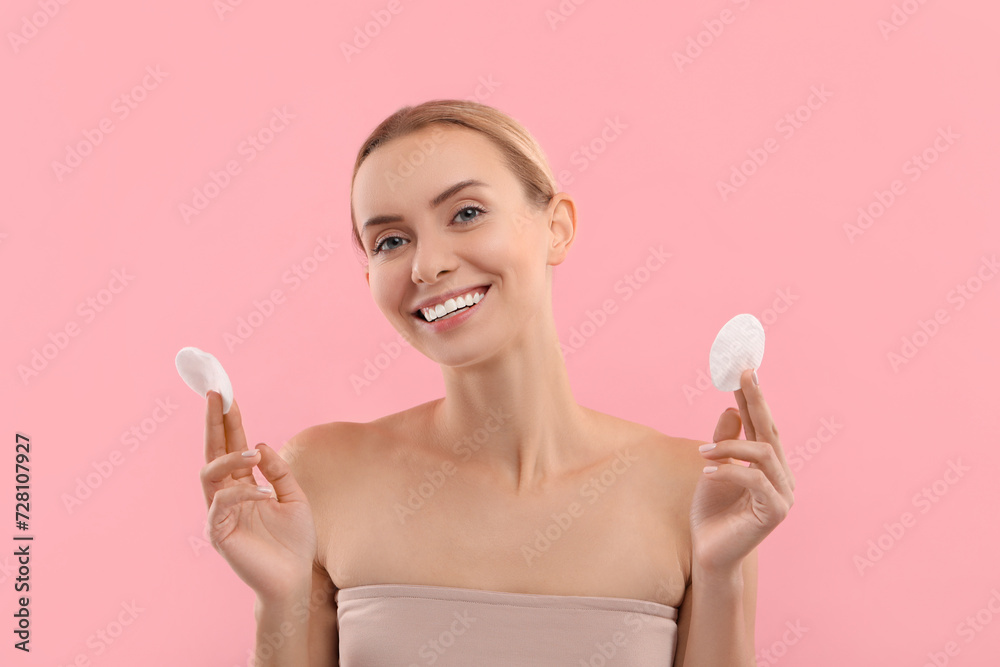 Removing makeup. Smiling woman with cotton pads on pink background Removing makeup. Smiling woman with cotton pads on pink background