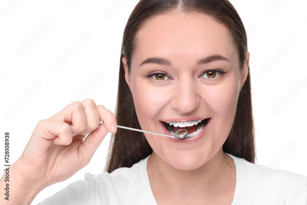 Woman with braces holding dental mirror on white background Woman with braces holding dental mirror on white background