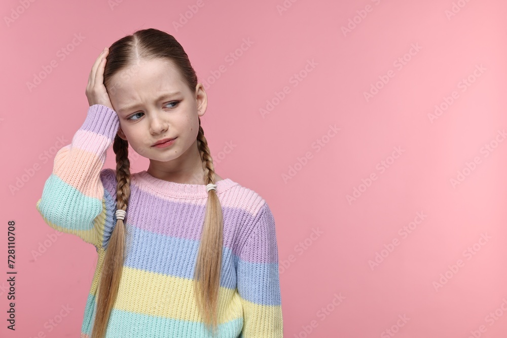 Little girl suffering from headache on pink background. Space for text