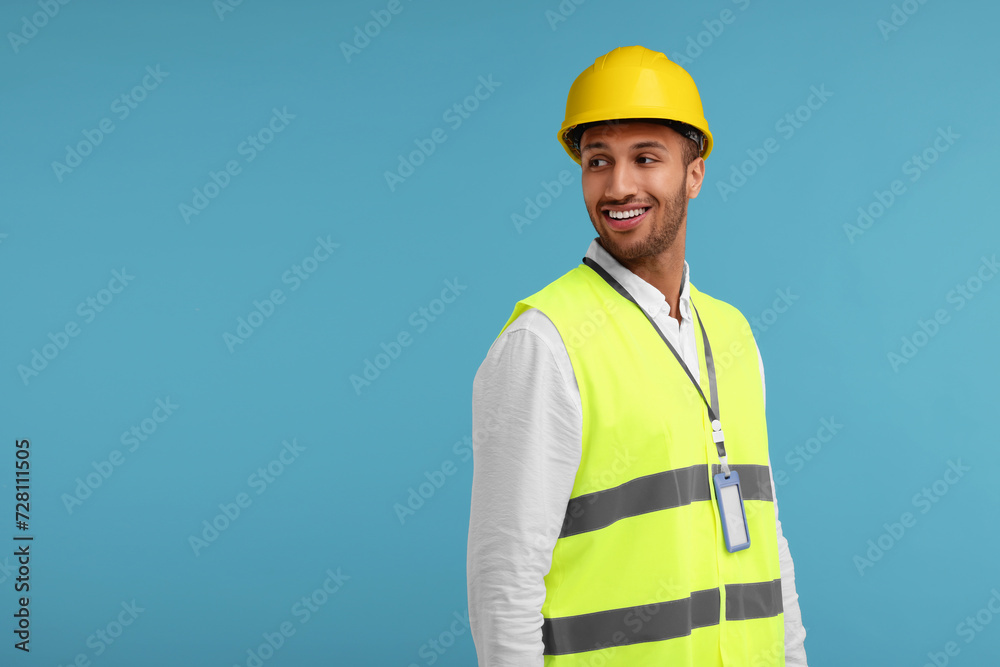 Engineer with hard hat and badge on light blue background, space for text Engineer with hard hat and badge on light blue background, space for text