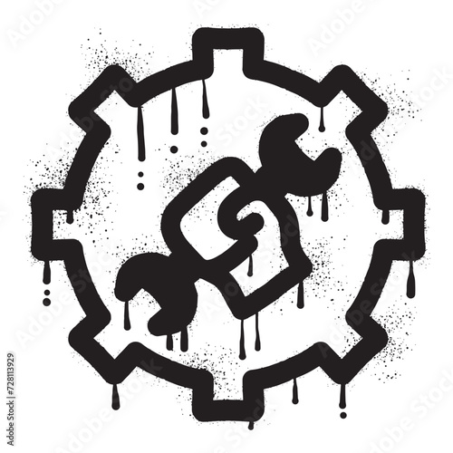 Graffiti hand holding wrench on gear wheel drawn with black spray paint