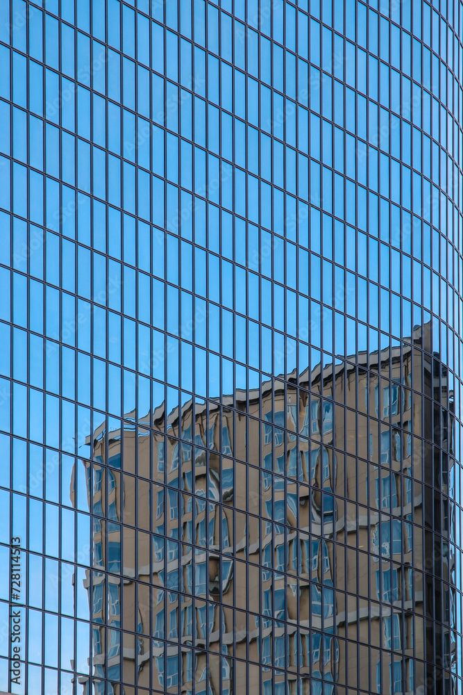 Blue glass skyscraper with the reflection of another building