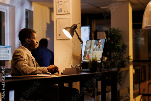 Manager discussing marketing strategy with remote team during videocall meeting conferece. Advisor agent working overhours at company profit progress, planning report with coworkers photo