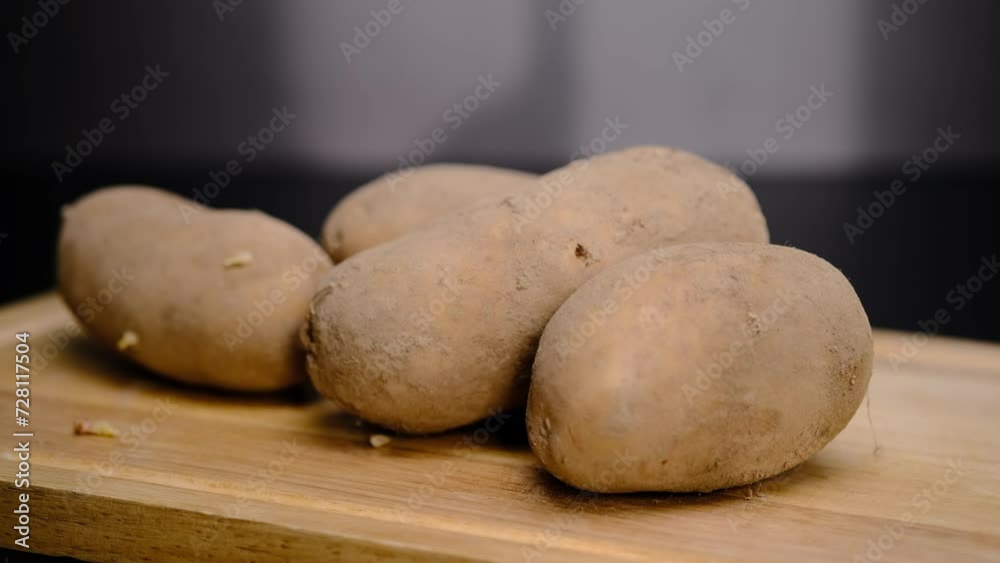 There are a lot of potatoes on a wooden shelf. Unpeeled potatoes There are a lot of potatoes on a wooden shelf. Unpeeled potatoes