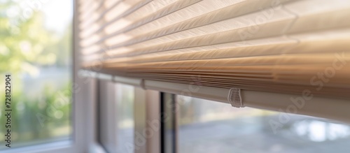 Large beige pleated blinds with a 50mm fold, close-up view in interior window openings. Modern privacy shades for apartment windows.