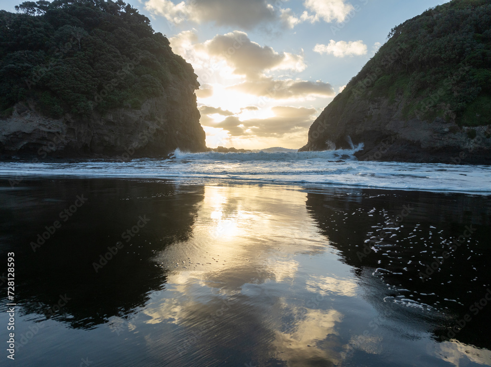 Waves crashing in an inlet at sunset. Bethells Beach, Auckland, New Zealand. Waves crashing in an inlet at sunset. Bethells Beach, Auckland, New Zealand.