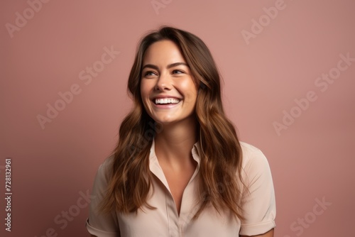 Happy young woman smiling and looking at camera. Isolated on pink background