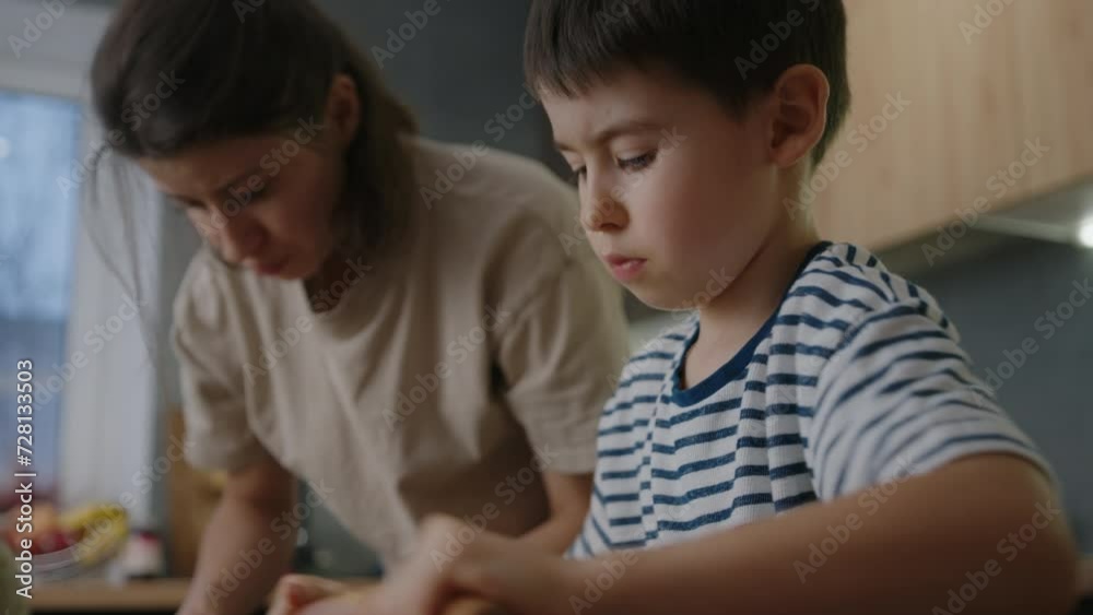 Mother with her kids cooking cookies and having fun in the kitchen. Homemade food and little helper. Happy loving family are preparing bakery together. Mother with her kids cooking cookies and having fun in the kitchen. Homemade food and little helper. Happy loving family are preparing bakery together.