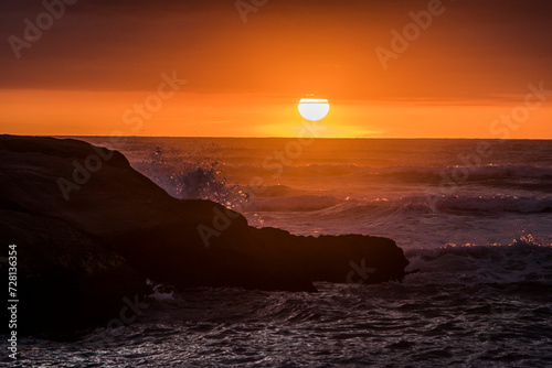 Sun falling behind the waves