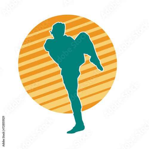 Silhouette of a kickboxer athlete in action pose. Silhouette of a sporty man doing kicking pose.