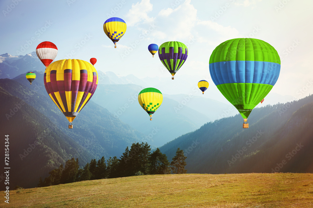 Bright hot air balloons flying over mountains