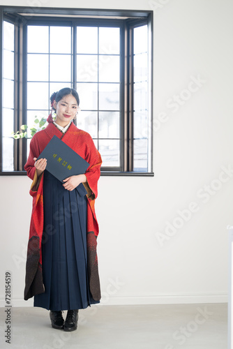 卒業証書を持つ袴を着た女性