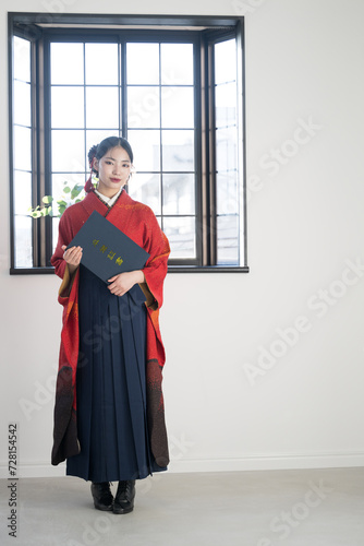 Japanese woman in hakama (kimono) holding diploma