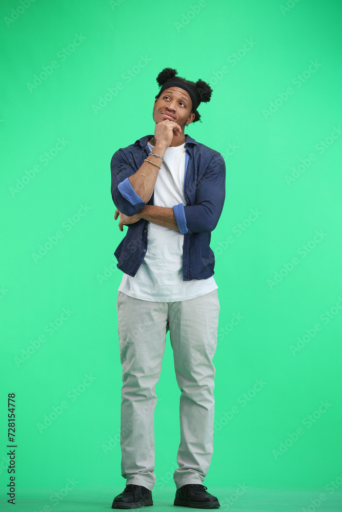 A man, full-length, on a green background, thinks A man, full-length, on a green background, thinks