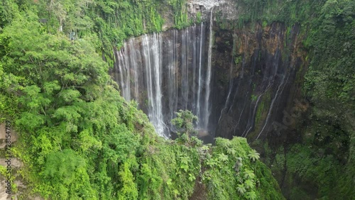 Aerial descent into lush jungle canyon at Tumpak Sewu waterfall, Java photo