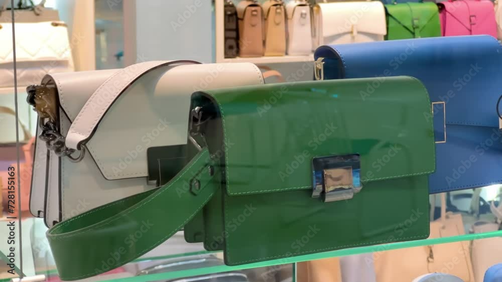 Women's leather colorful handbags on the glass shelf of an accessories store Women's leather colorful handbags on the glass shelf of an accessories store
