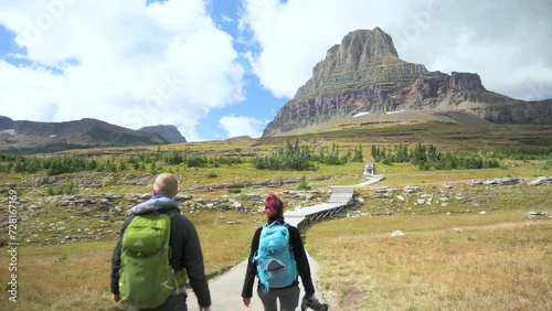 Hikers walking towards Clements Mountain on the Hidden Lake Trail in Glacier National Park, static photo