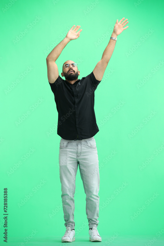 A man, on a green background, in full height, waving his arms