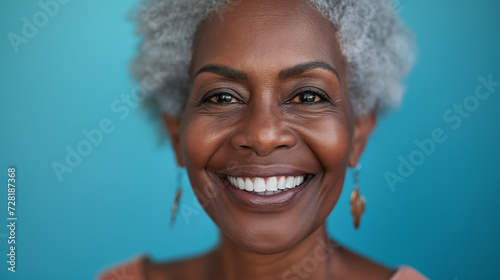 a happy black elderly woman with a beautiful white smile on blue background