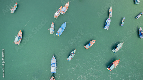 Aerial view of multiple colorful boats floating on serene water, depicting a calm fishing village scene or a leisure maritime setting photo