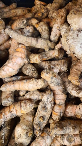 Close up pile of tasty fresh turmeric sold at the market as a background.