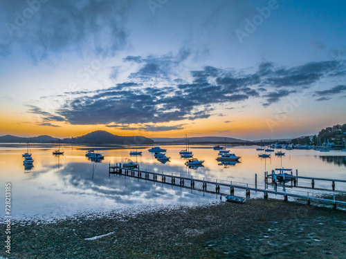 Aerial sunrise waterscape with boats  reflections and low cloud