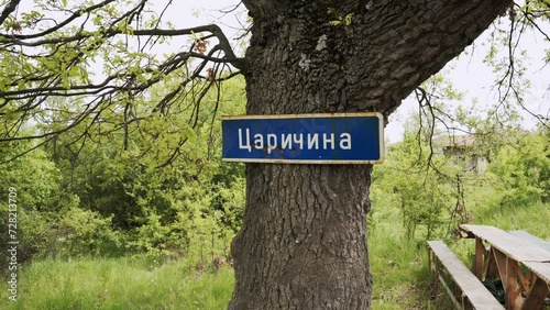 Panning from the left to the right side of the frame showing a sign of Kralicka posted on a tree in what is known as Area 51 or Tsacharina Hole in Bulgaria. photo