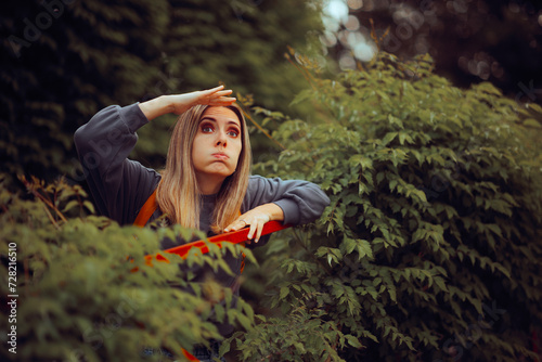 Funny Woman Spying from a Bush outdoors in Nature. Curious girlfriend stalking and surveilling from a distance 
