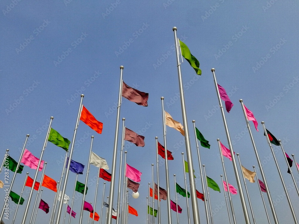 Bunch of different colored flags on the pole. Symbol of unity, equity, friendship, love, progress. Flags fluttering background for conference, camping, summit, festival, event, campaign banner poster Bunch of different colored flags on the pole. Symbol of unity, equity, friendship, love, progress. Flags fluttering background for conference, camping, summit, festival, event, campaign banner poster