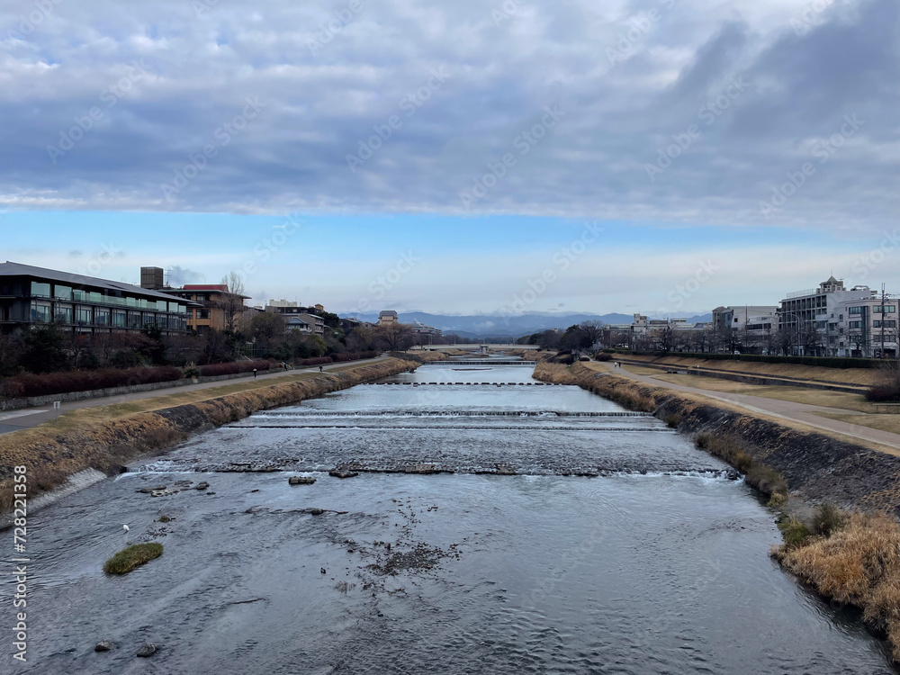 冬の曇空の下を流れる京都鴨川