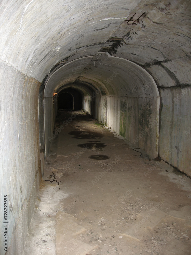 Dark narrow concrete underpass, underground Stone tunnel Inside the Vladivostok fortress, Russia