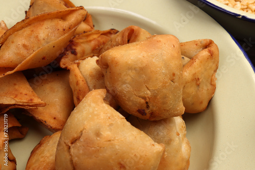 Deep fried samosa singara stuffed with potato minced meat vegetable benglai snacks on enamel tin metal plate photo