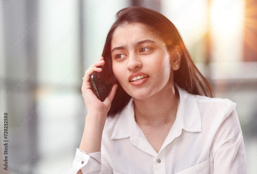 Portrait of young business woman with glasses ofand talking on mobile phone Portrait of young business woman with glasses ofand talking on mobile phone