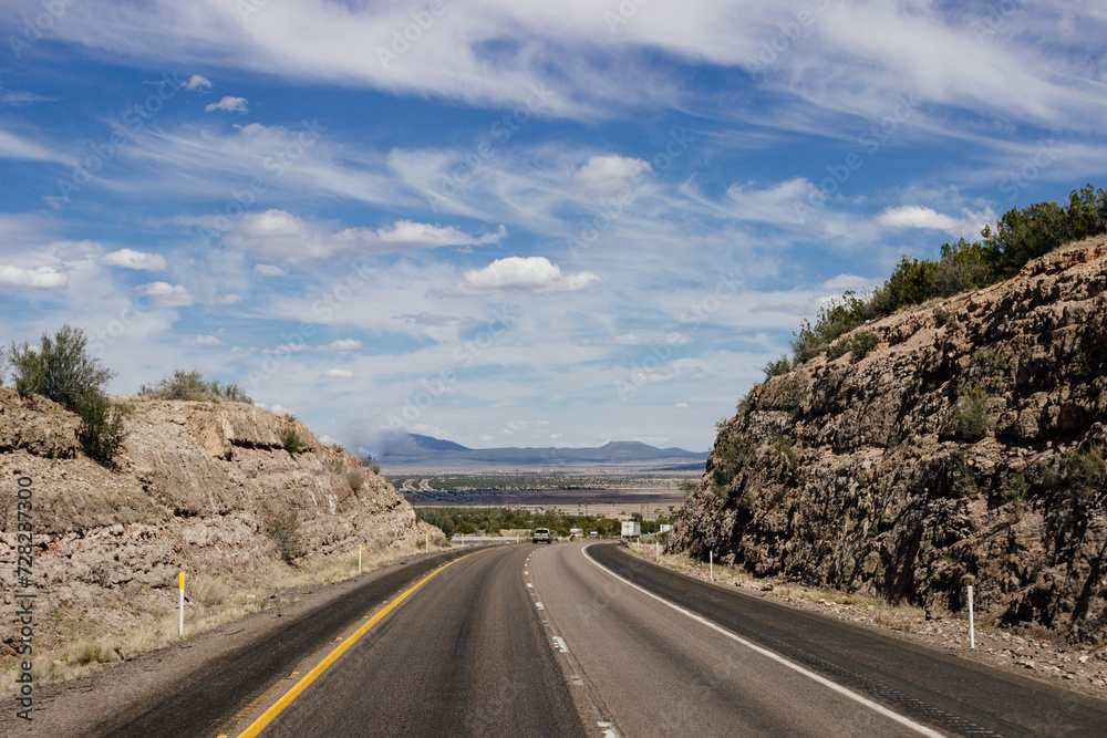 Beautiful blue sky with fluffy clouds over the highway. Scenic road in Arizona, USA on a sunny summer day. 40 hwy, 10 hwy in Arizona, USA - 17 April 2020