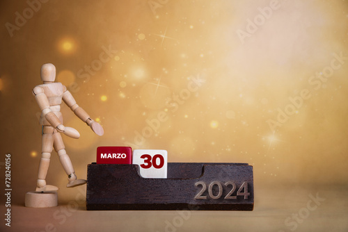 March's vibrant presentation: Wooden figure points to the thirtieth day on a bright calendar with warm-toned hues.