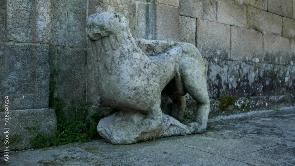 Carved stone animal outside of monastery against old walls