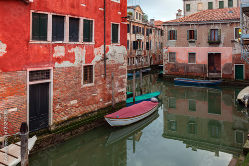 Small boat on a small canal street in Venice of beautiful colorful houses, Italy