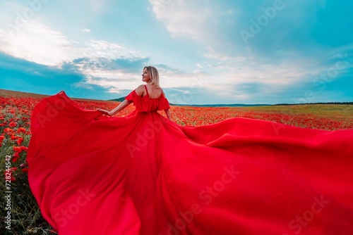 Woman poppy field red dress. Happy woman in a long red dress in a beautiful large poppy field. Blond stands with her back posing on a large field of red poppies