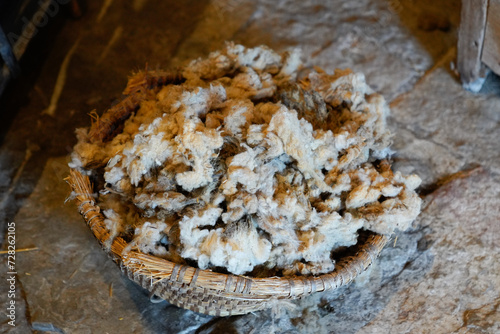 combed cut wool virgin raw from a sheep in a wicker basket