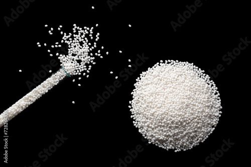 Obraz na płótnie Top view of a laboratory glass flask with samples of white polymer plastic granules