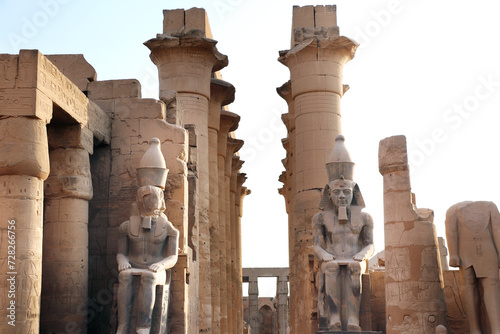 Ancient Statue of Ramesses II, Luxor Temple, in the light of sunset. Great columns and sculptures at entrance of famous landmark - Egyptian temple as Luxor (Thebes), Egypt, North Africa