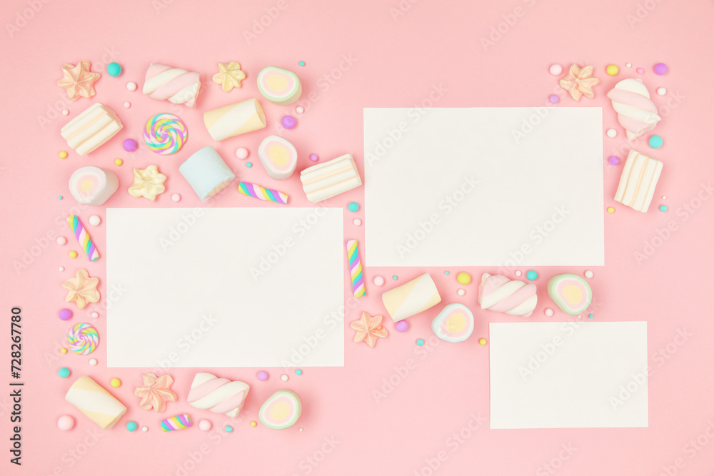Set of three blank white cards on cute pastel pink kawaii background with frame of sweet candies, meringue and marshmallows . Flat lay, top view, copy space. Beautiful childlike design template