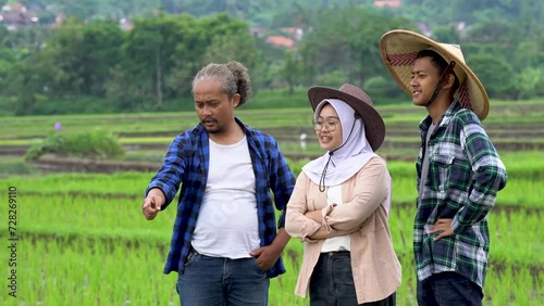 Experienced Asian farmer guides young colleagues through a vibrant rice paddy, fostering knowledge transfer and sustainable agricultural innovation for prosperous harvests.