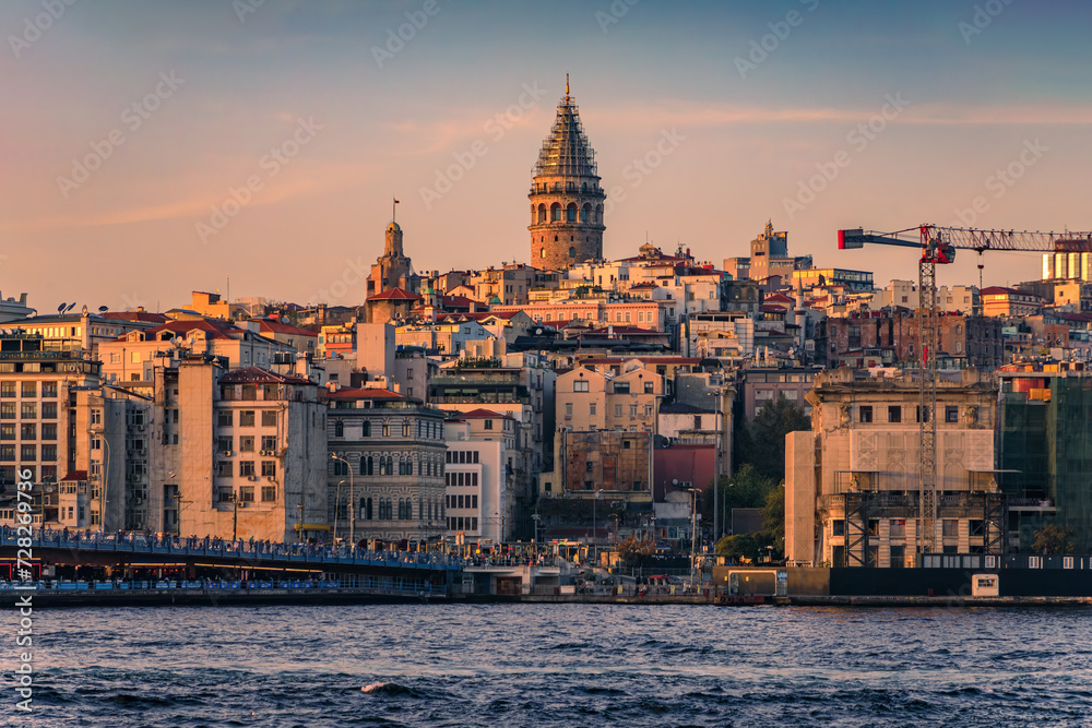 Sunrise cityscape of the Karakoy area across Bosphorus Strait by Galata Bridge with the Galata Tower at the golden hour of sunset in Istanbul, Turkey