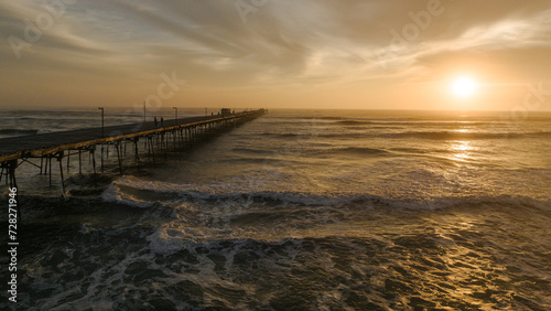 Pier in the ocean on a colorful sunset. Puerto Eten.