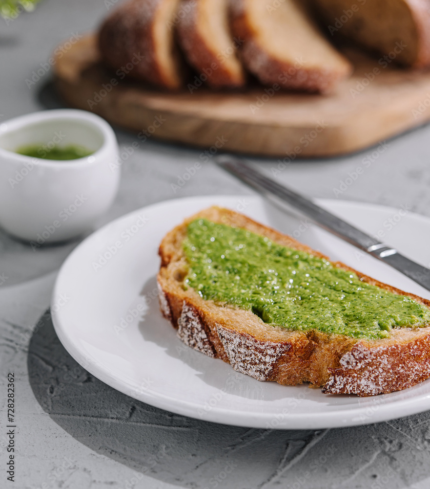 bread with homemade pesto sauce spread with a knife