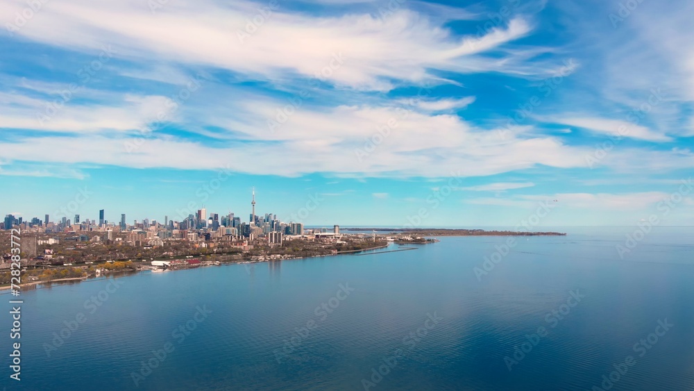 Calm day Canadian lake, Toronto shores, plane takes off. Tourism, tranquil lake. Serene lake, backdrop. Tourism nature blend beautifully. Tourism experience, dynamic. Lake's appeal. Drone view.